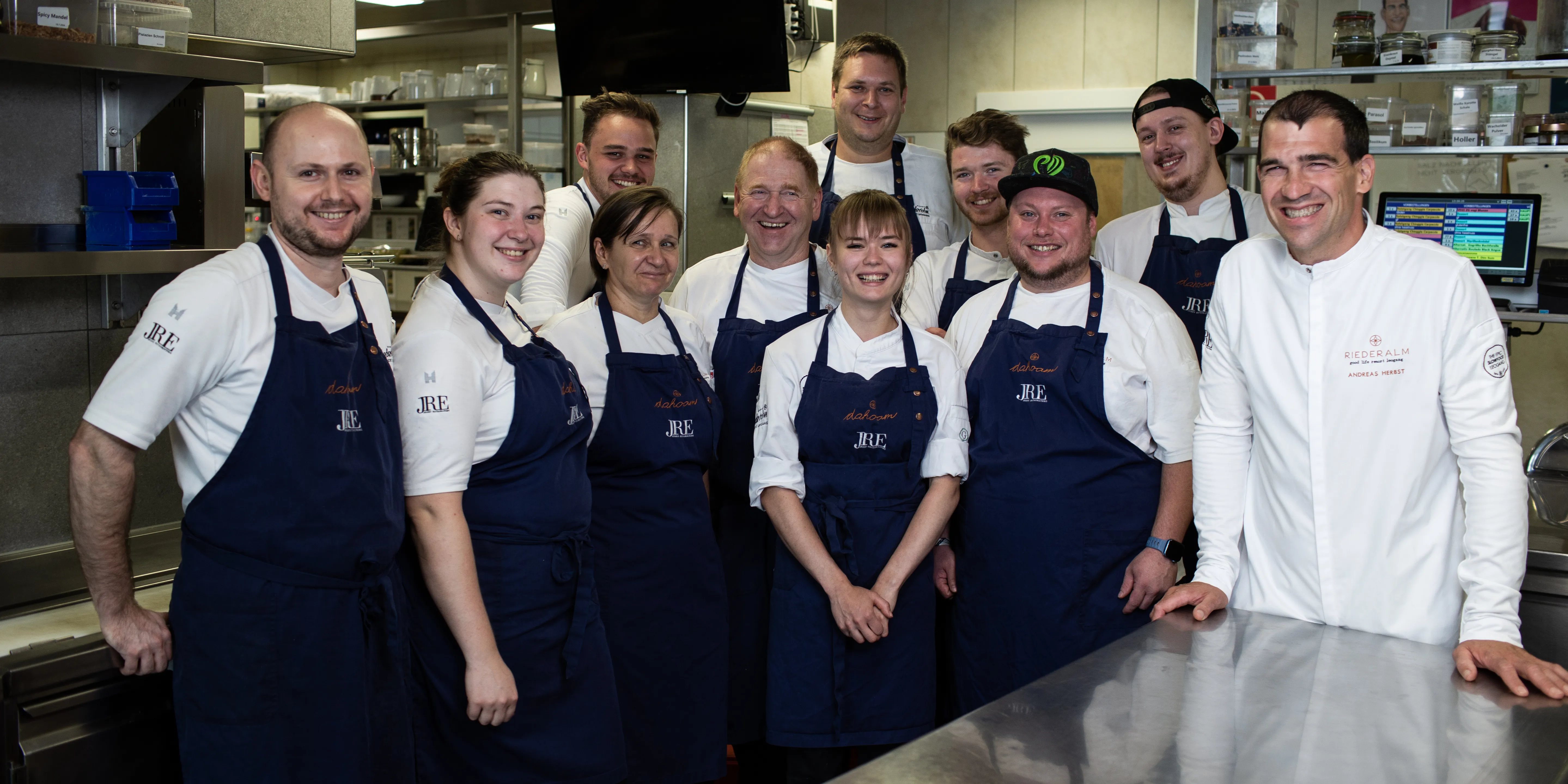Team von Köchen in blauer Schürze in professioneller Restaurantküche